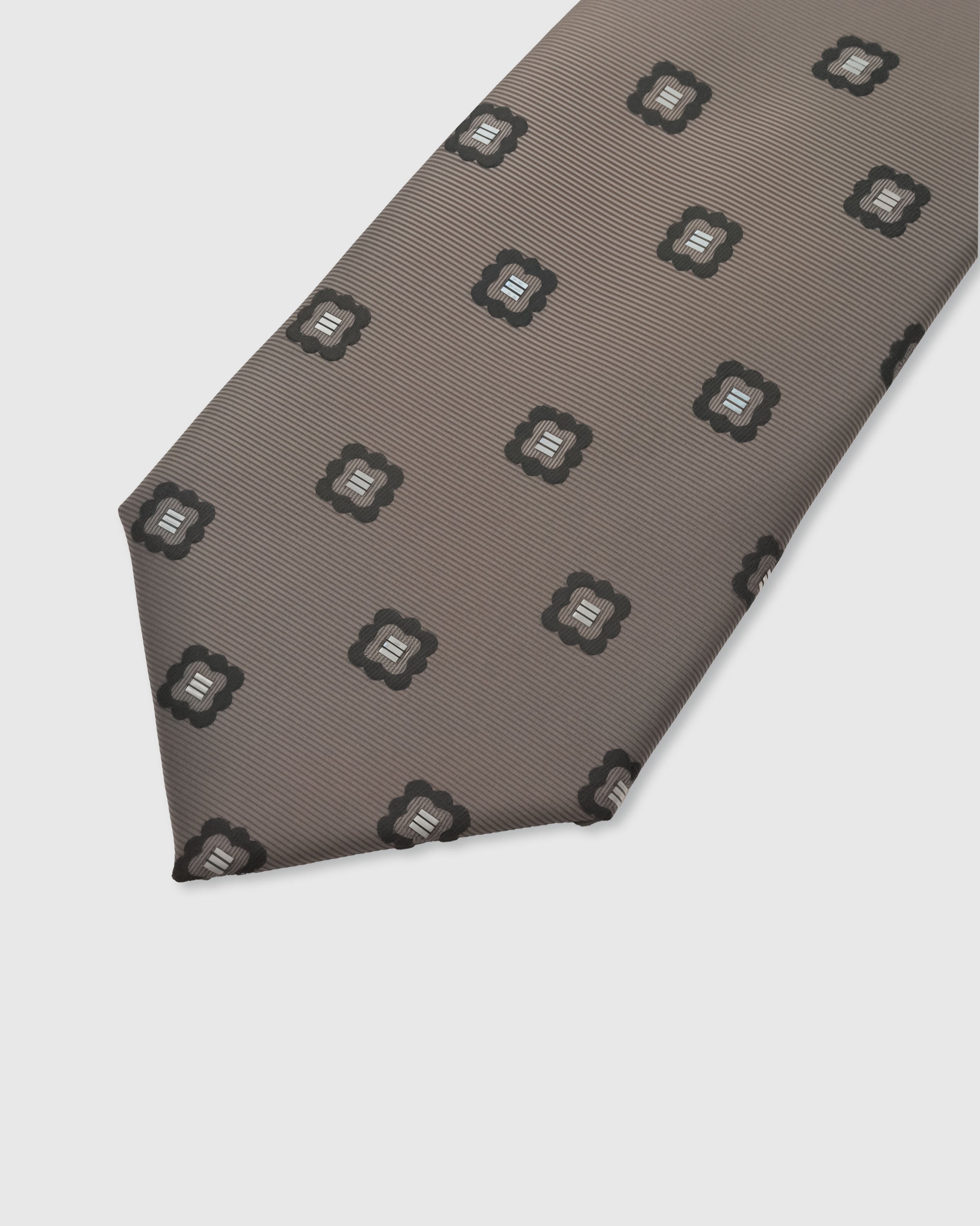 STICKYZOO Taupe Crest Tie — detail of hand-embroidered spaced crest motif on pure mulberry silk