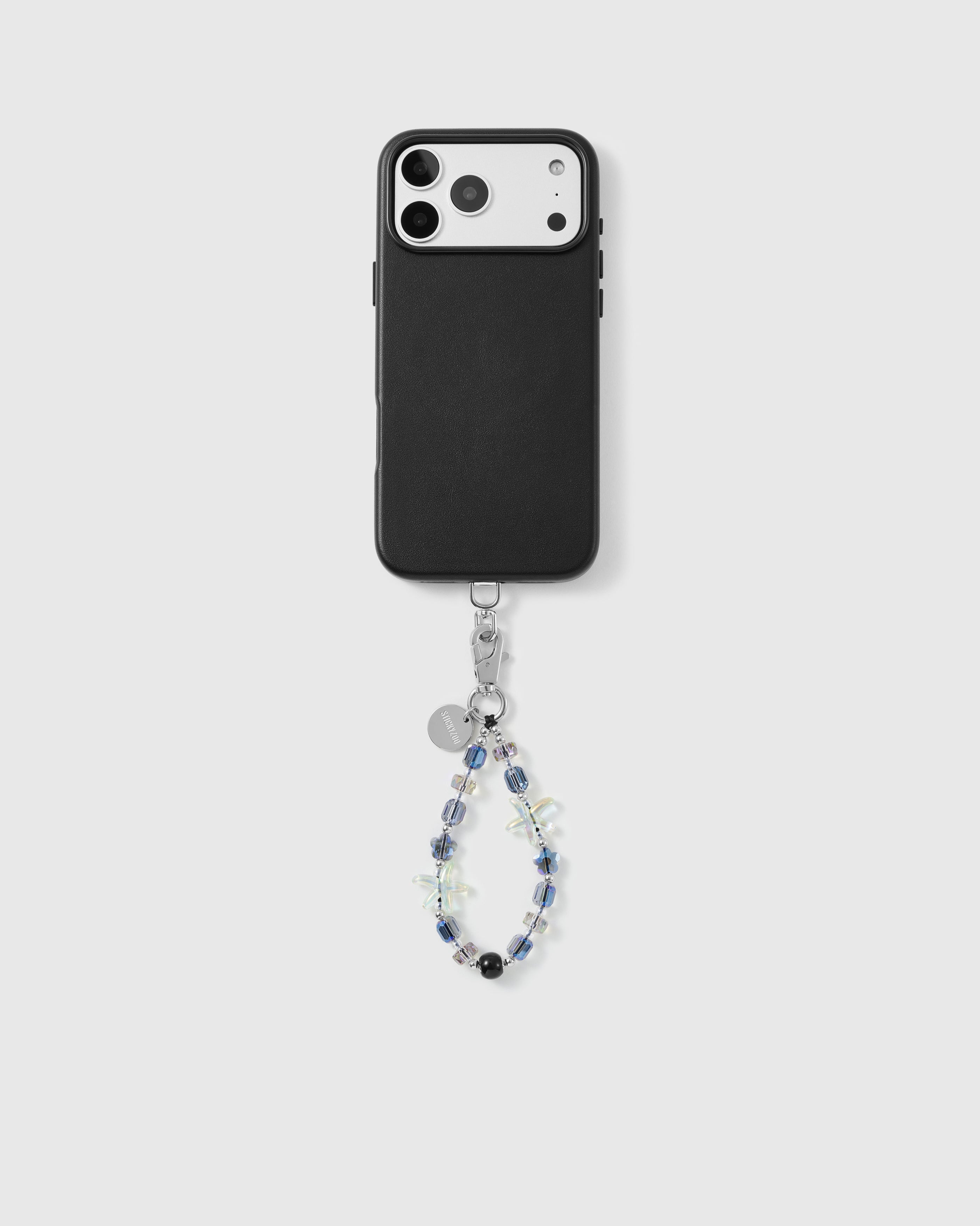 Aurora Starfish strap looped from the base of a black phone case, showing iridescent aurora beads, jelly starfish and a glossy black bead