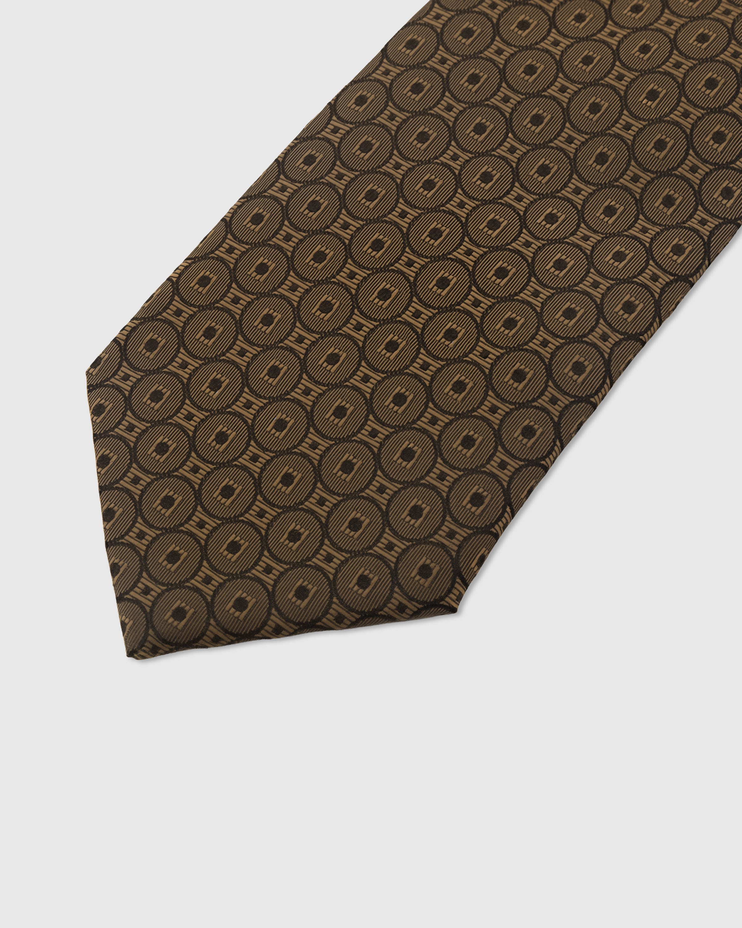 Coin medallion detail on umber mulberry silk tie showing concentric hand-embroidered rings by STICKYZOO