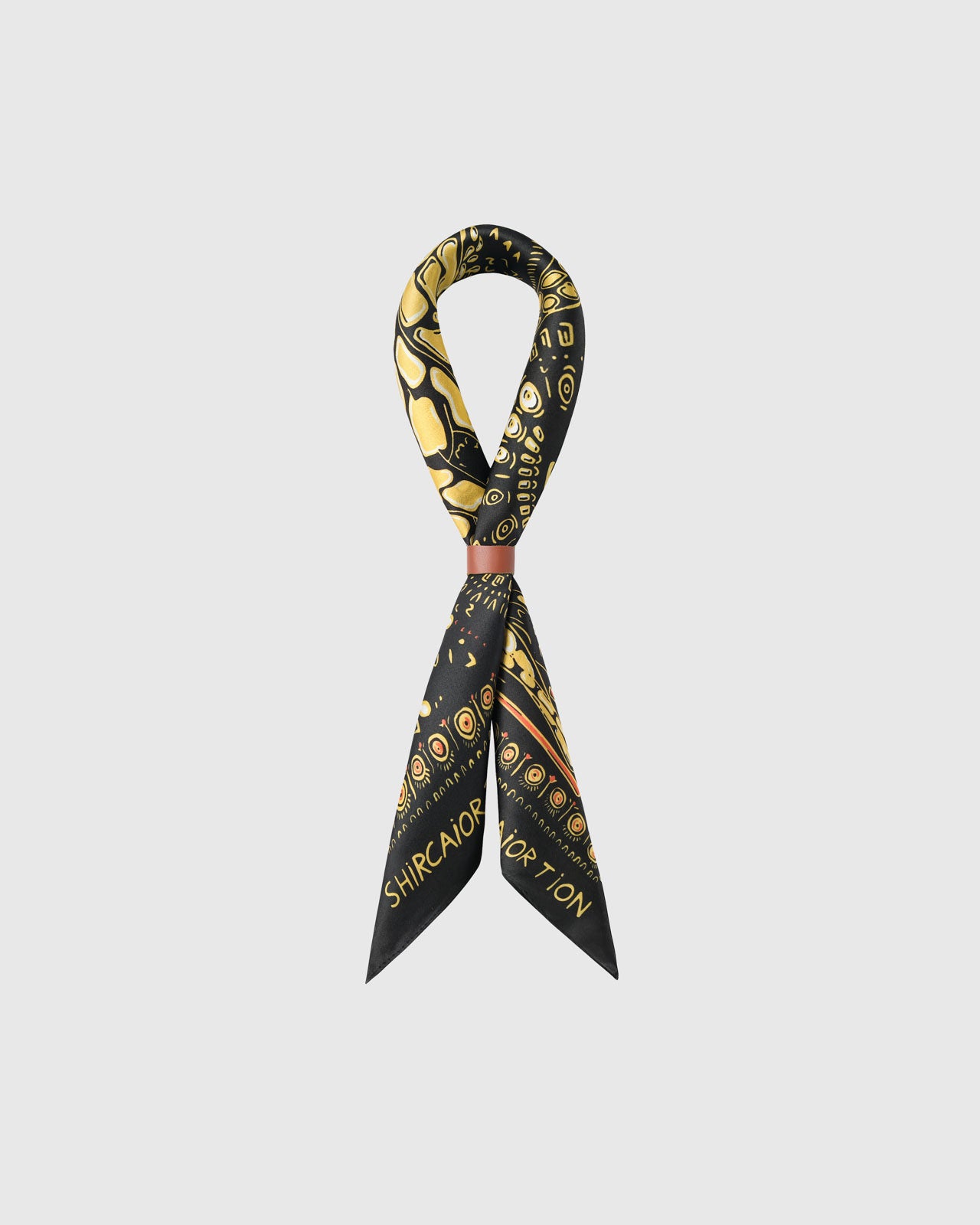 STICKYZOO golden savanna silk scarf folded into a bow showing the black border and the figures along the field