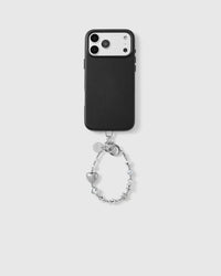 Black phone case shown from the back, camera side up, with the silver heart-and-star beaded wrist strap looped from the base, hardware clasp and beads visible