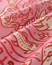 STICKYZOO wildwood carnival silk scarf folds catching light against the pink field and cherry-red ink
```