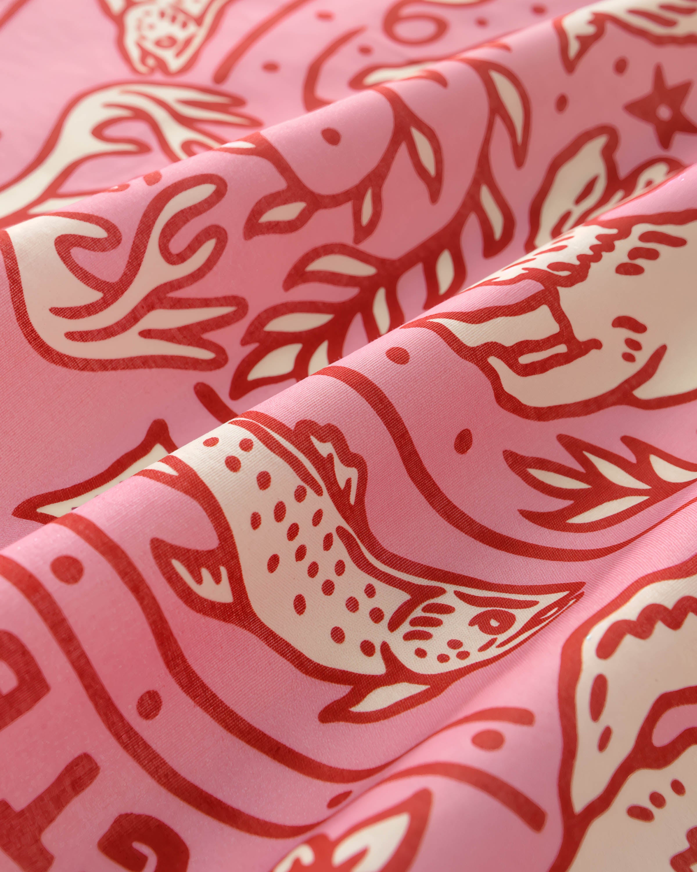 STICKYZOO wildwood carnival silk scarf folds catching light against the pink field and cherry-red ink
```