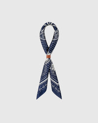 Pure silk bandana scarf folded to show the soft hand and the ivory bandana details on navy