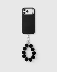 Noir plush sphere phone strap attached to black phone case showing universal fit