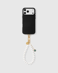 White heart phone strap with eye amulet worn as a wrist loop showing hands-free carry