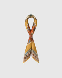 STICKYZOO saffron silk scarf looped through a leather slide showing the medallion print and warm border