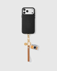 Close-up of orange and silver vintage rangefinder camera charm showing enamel body and polished lens detail