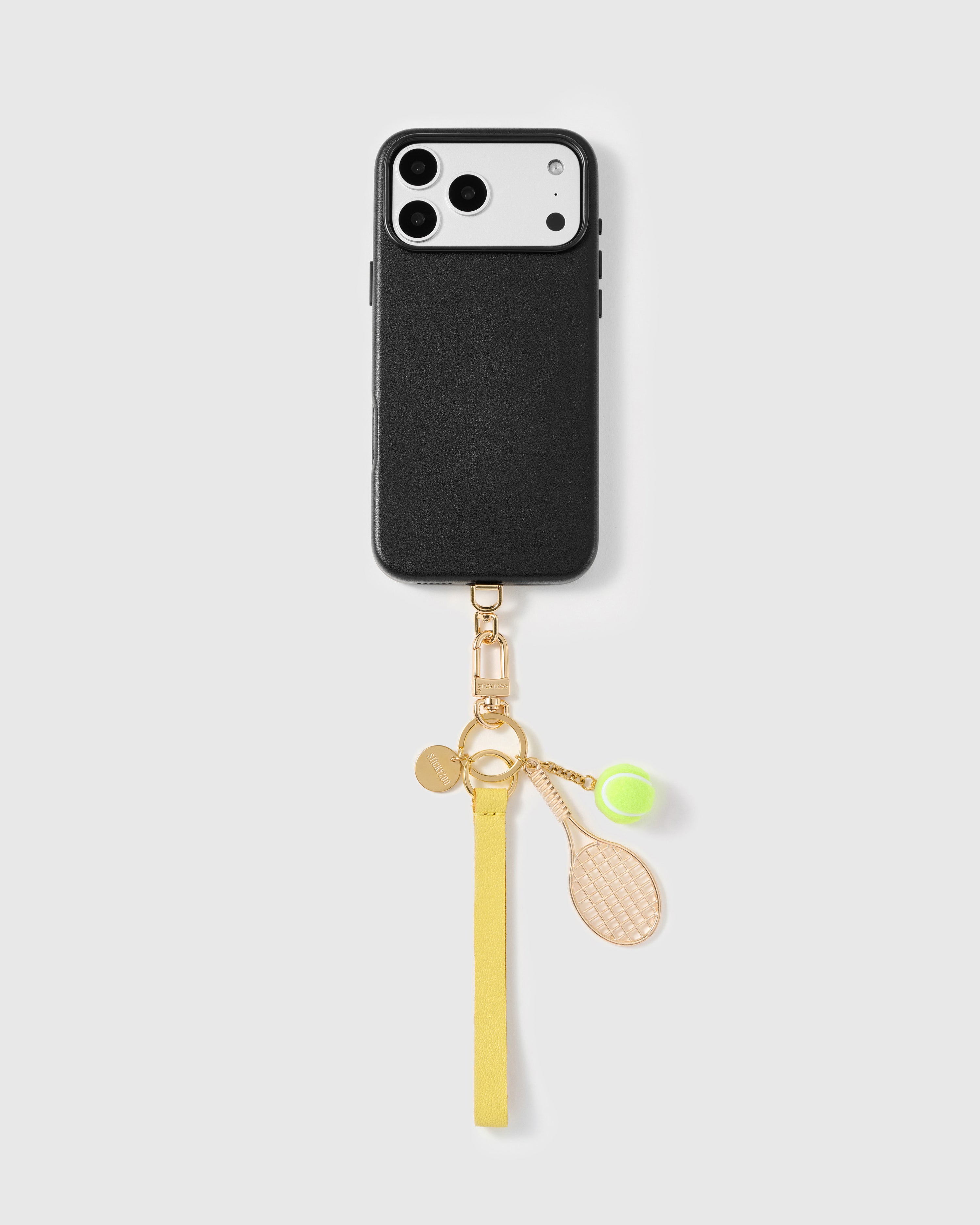 Close-up of gold racquet charm and hand-felted yellow tennis ball with chain detail