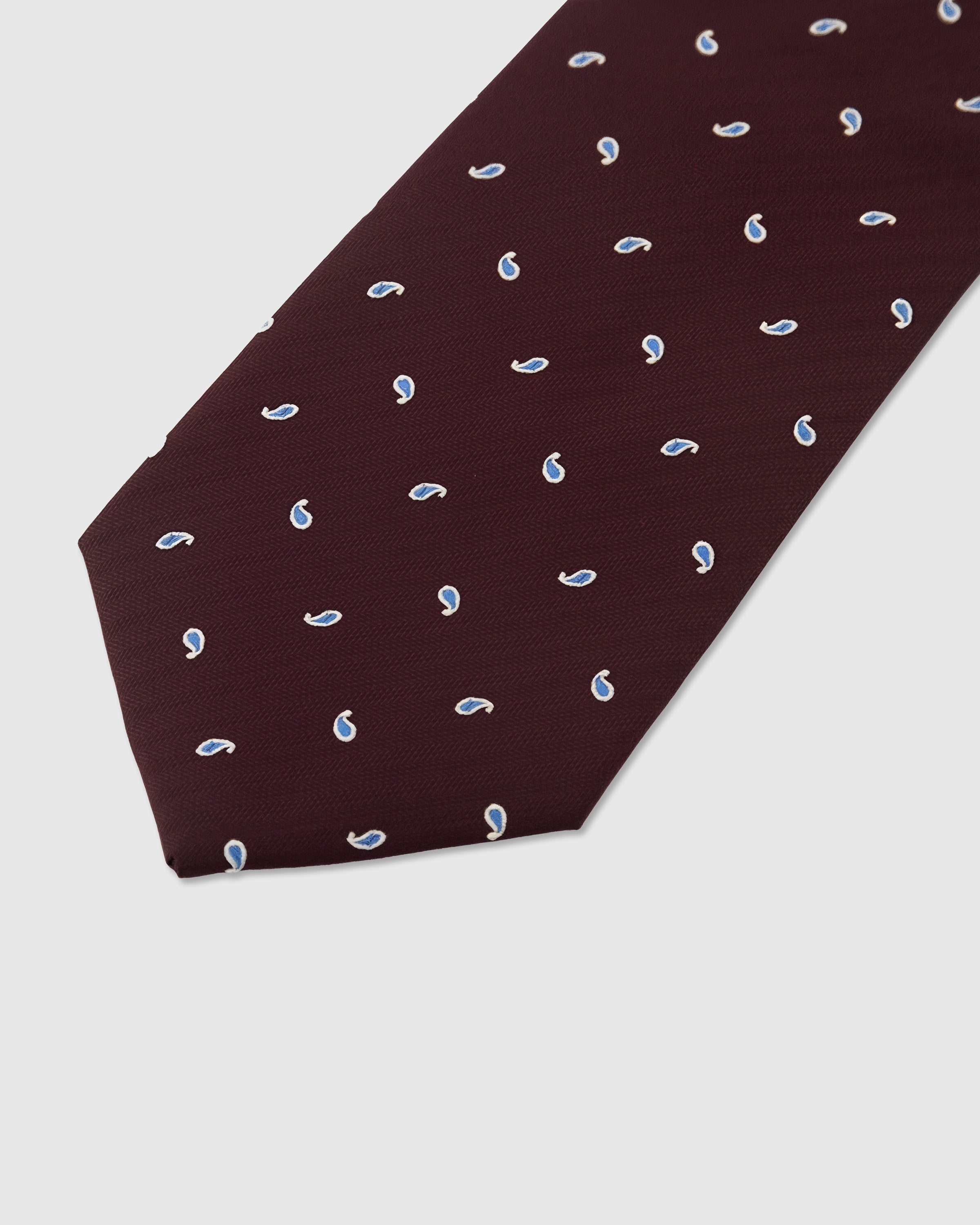 Blue paisley drop detail on burgundy mulberry silk tie showing hand-embroidered stitching by STICKYZOO