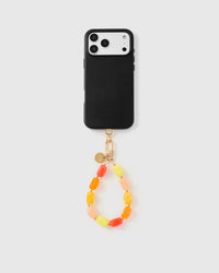 Full phone with citrus agate strap attached on grey background