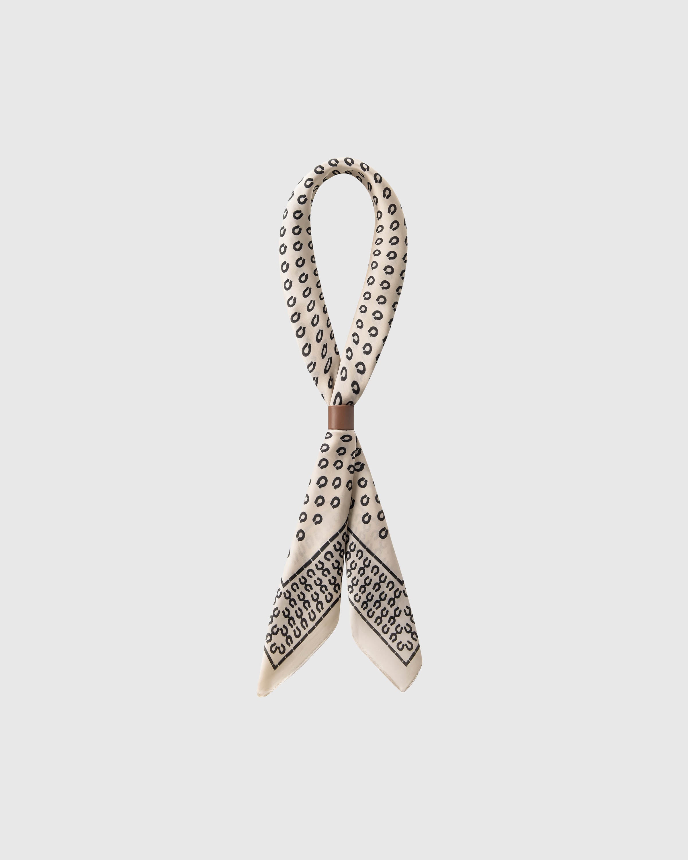 STICKYZOO horseshoe luck silk scarf looped and gathered with a slide showing the scattered horseshoe motif