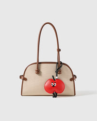 STICKYZOO leather apple charm clipped to a bag, a design-forward conversation piece