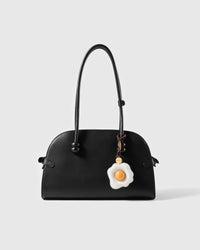 STICKYZOO leather fried egg charm shown on a handbag, French goatskin, hand-stitched over three days