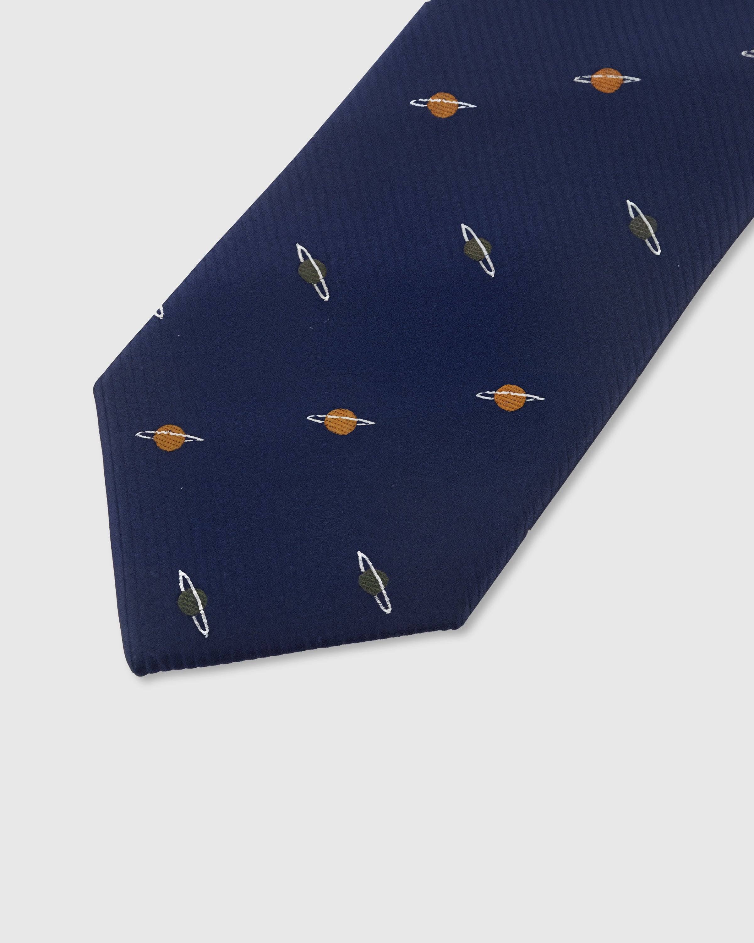 Copper Saturn motif detail on navy mulberry silk tie showing raised hand-embroidered rings and sphere by STICKYZOO