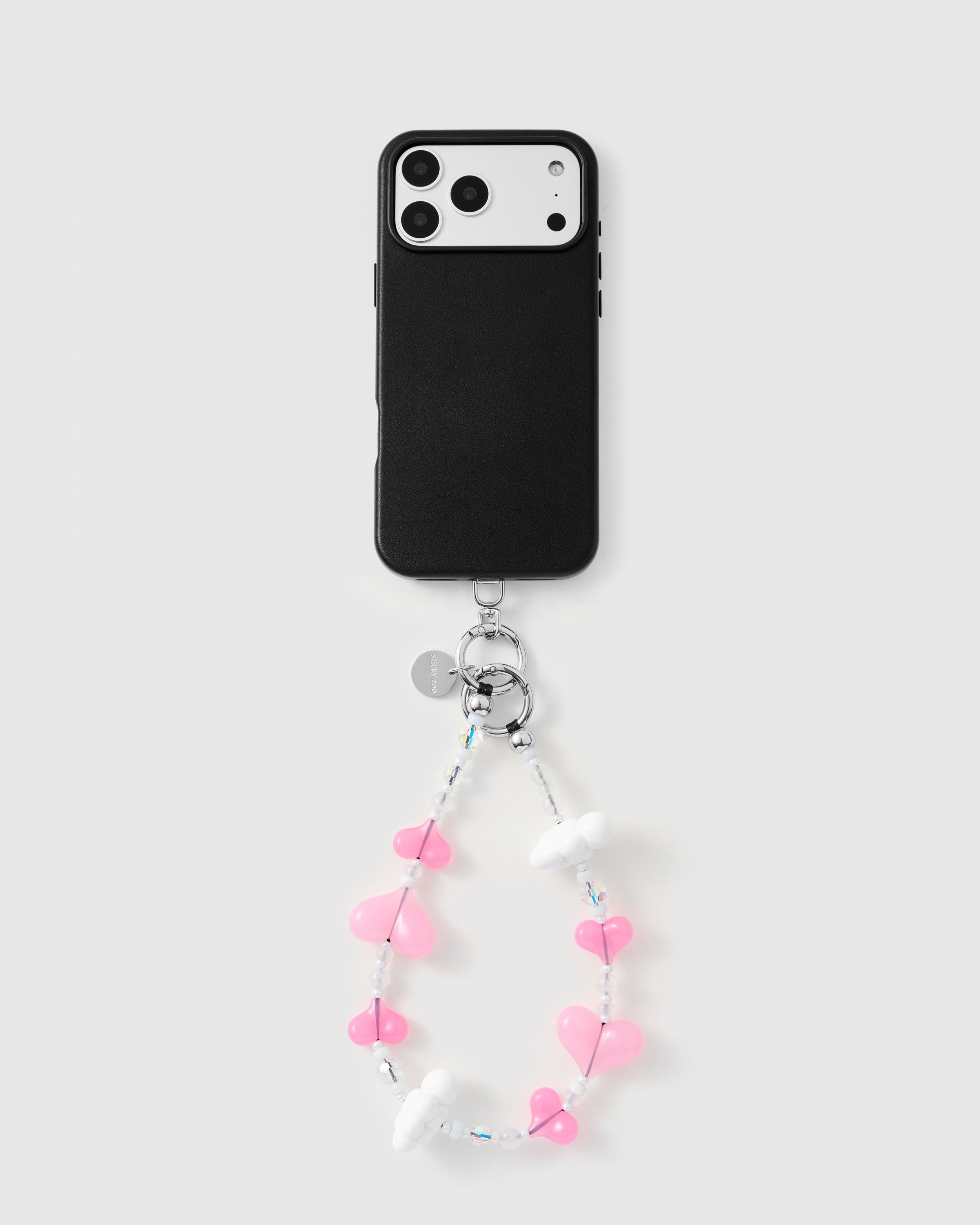 {{Works with any case}} Full phone with pink heart and cloud strap attached on light grey background
