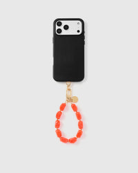 Full phone with coral agate strap attached on grey background