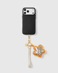 Zebra calf-hair star phone strap clipped to a black phone case, worn hands-free from the wrist