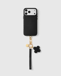 Close-up of four-leaf clover charm showing hand-set black crystal pavé on gold backing