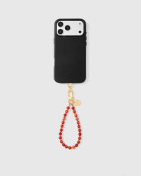 Full phone with scarlet stone bead strap attached on light grey background