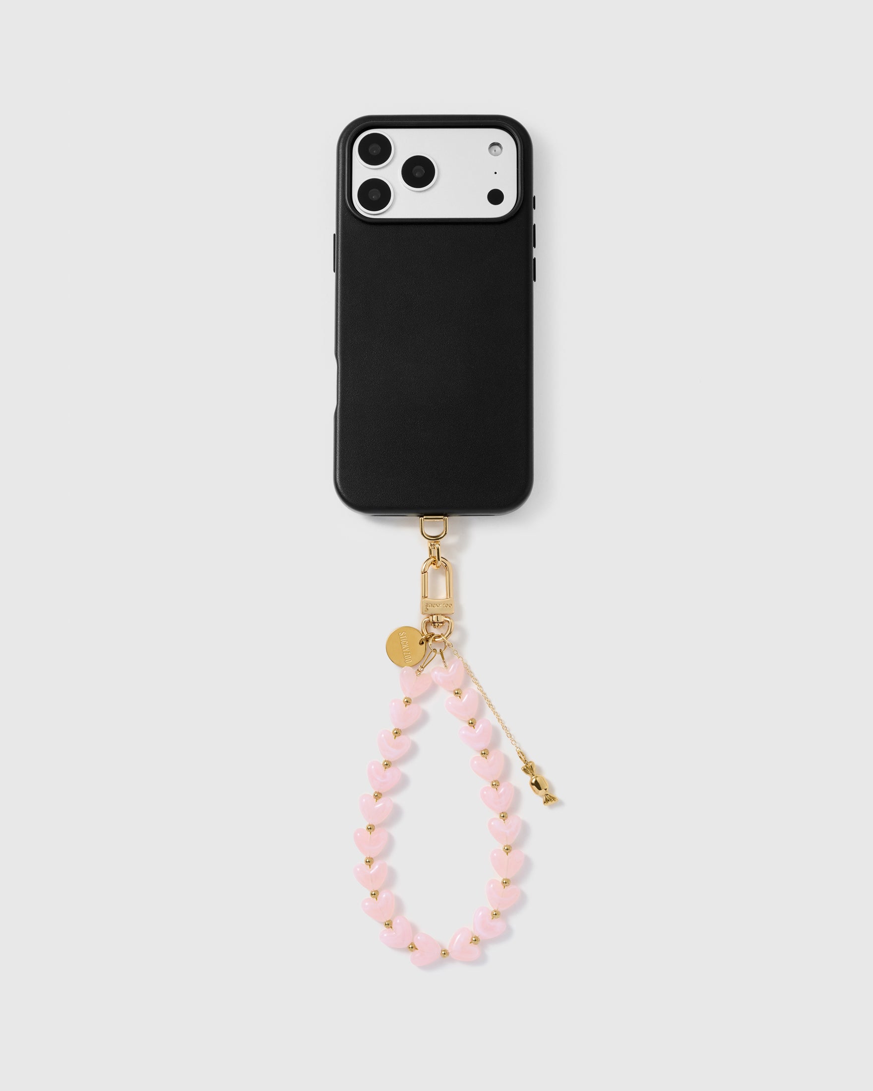 Pale pink heart phone strap worn as a wrist loop with phone case for hands-free carry