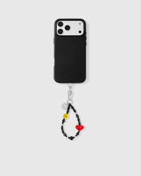 Phone with noir heart smiley strap attached showing universal compatibility
