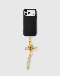 Champagne bow phone strap attached to black phone case showing wrist carry functionality