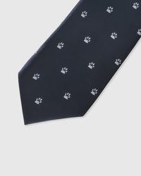 Embroidered, not printed STICKYZOO Paw Mark Tie flat blade showing repeating white paw print motifs on dark navy mulberry silk