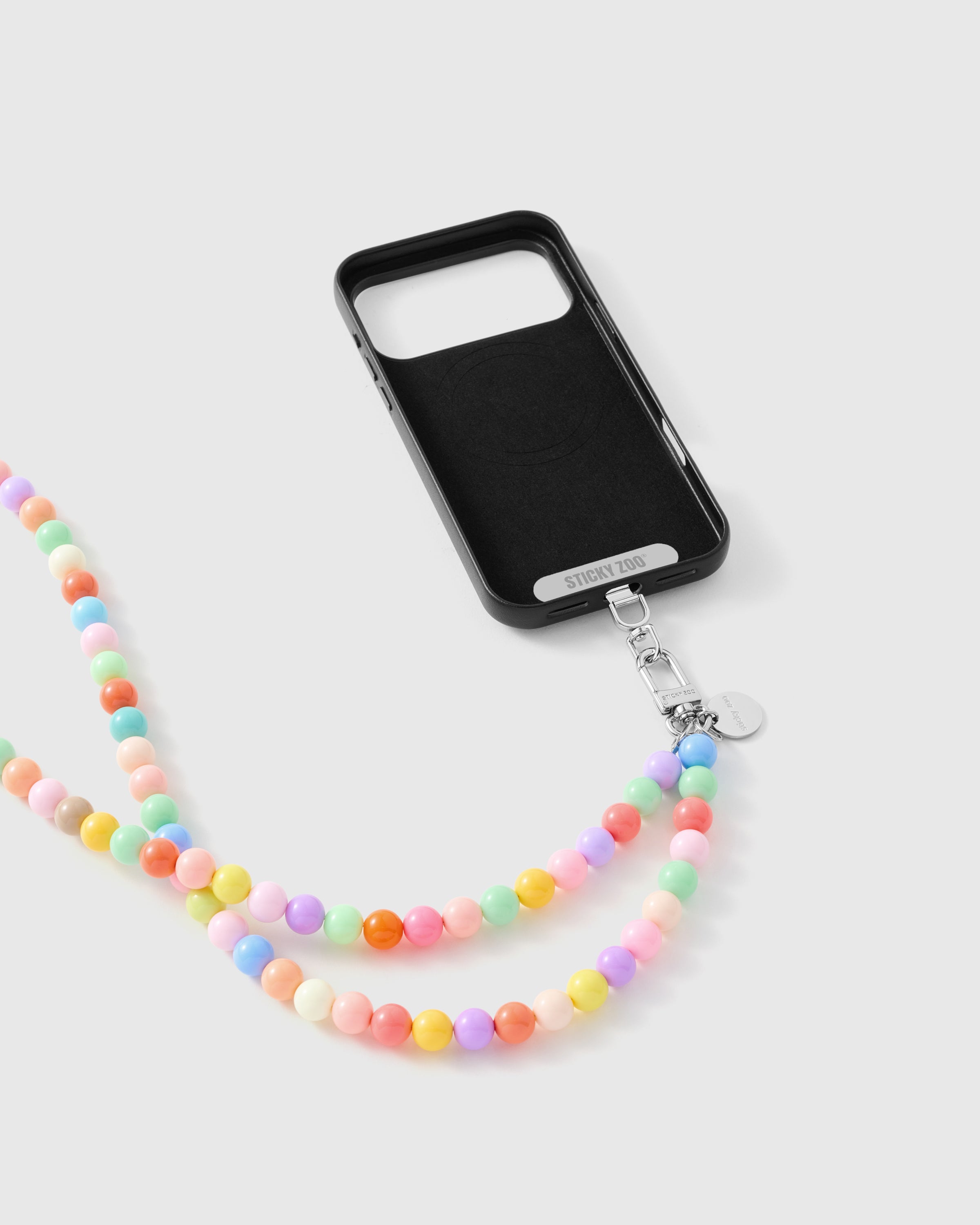 Phone Strap Card seated in a phone case, showing the pastel cross-body strap fits any case. Phone case sold separately.