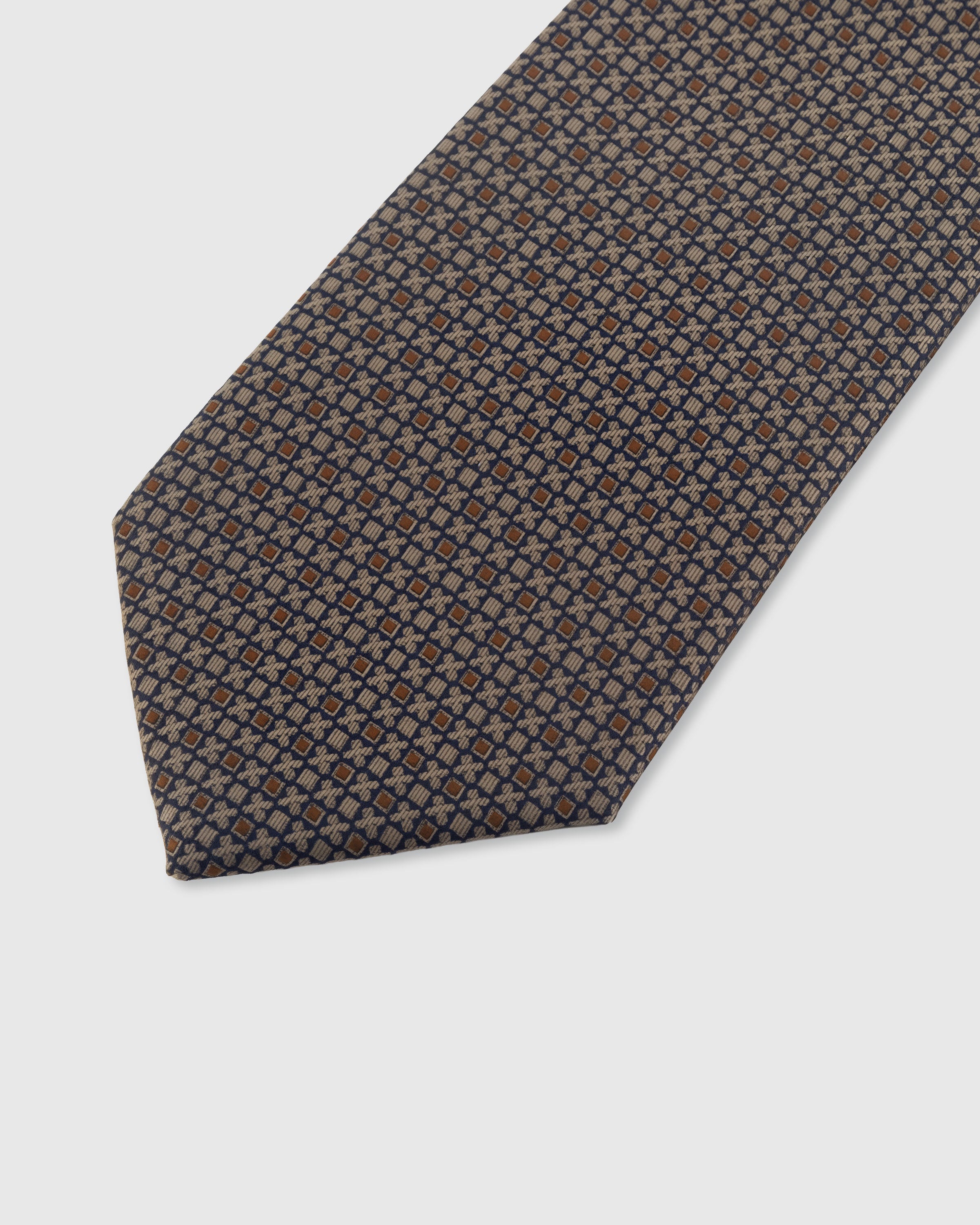 STICKYZOO TAUPE LATTICE TIE — hand-embroidered detail showing fine lattice of copper and navy geometric motifs, stitched not printed