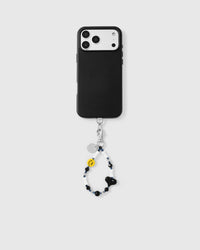 Phone with black smiley heart strap attached on light background showing universal fit
