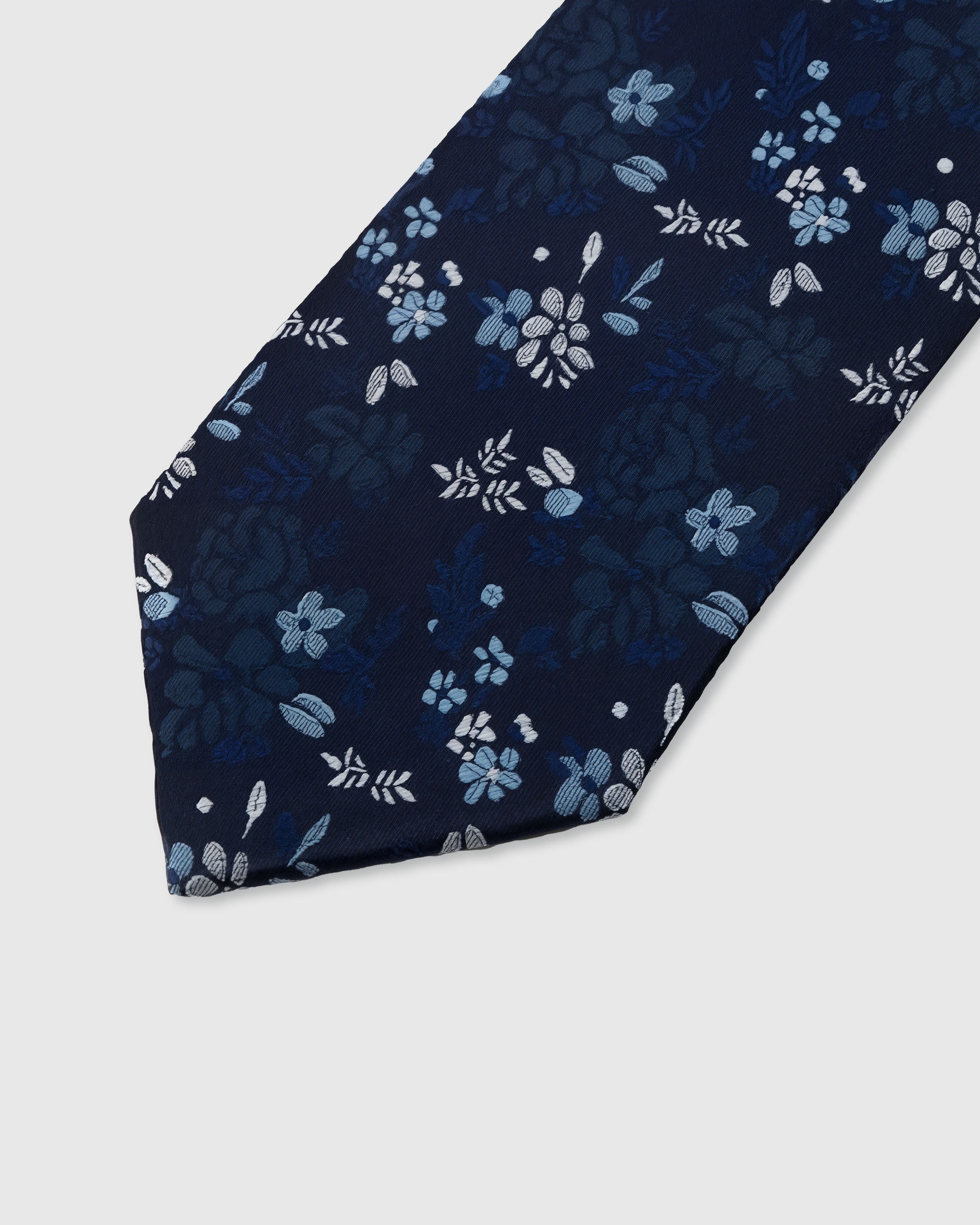 STICKYZOO MIDNIGHT BLOSSOM TIE — hand-embroidered detail showing scattered pale blue and silver blossoms with foliage, stitched not printed
