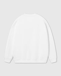 Back view of white cotton sweatshirt showing ribbed cuffs and relaxed oversized fit
