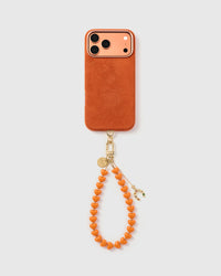 {Works with any case} Tangerine horseshoe heart phone strap hanging from phone case as a wristlet