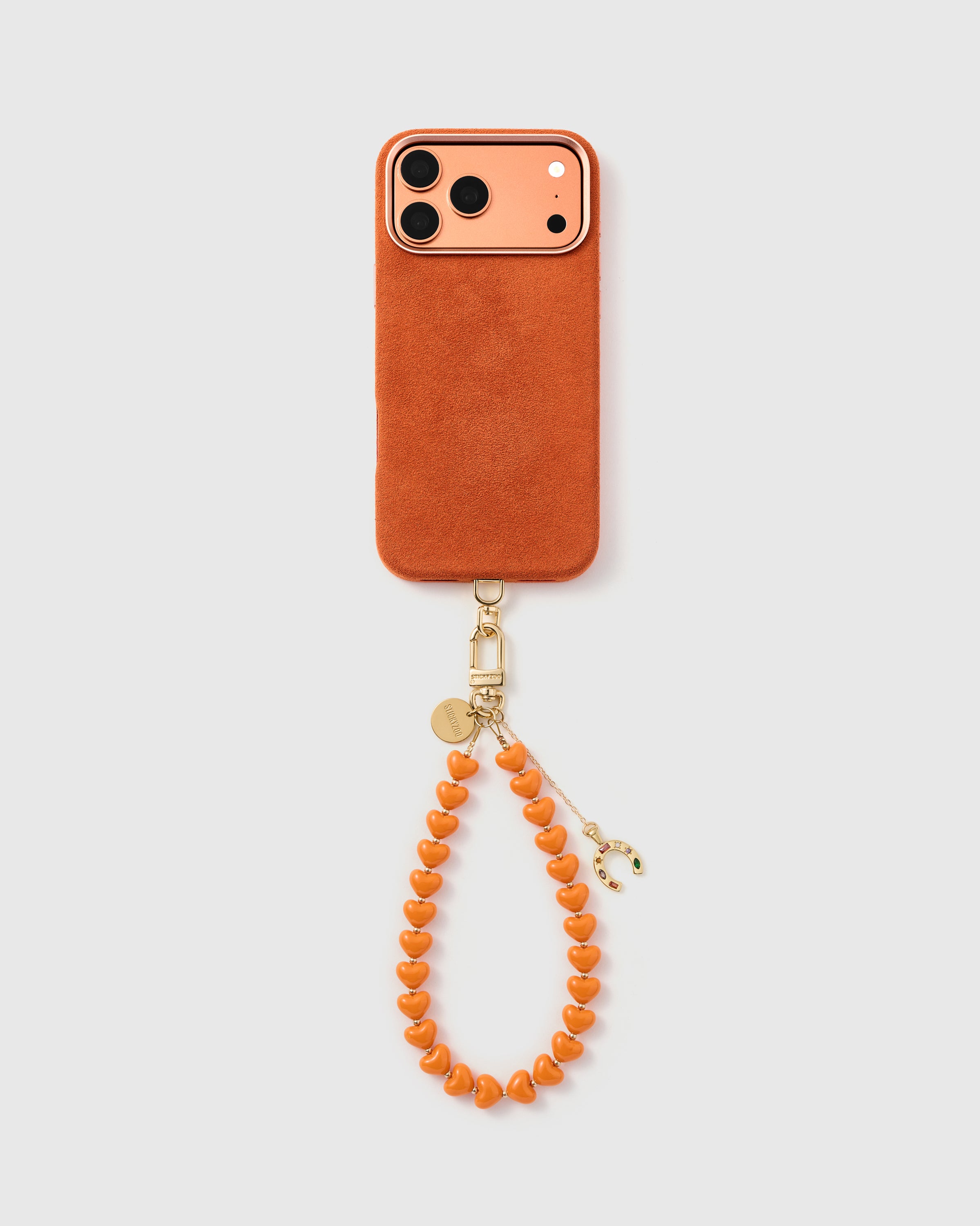 {Works with any case} Tangerine horseshoe heart phone strap hanging from phone case as a wristlet