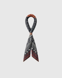 STICKYZOO bandana silk scarf looped through a leather slide showing the paisley border drape