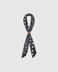 STICKYZOO monochrome silk scarf knotted through a leather slide showing the paisley and polka quadrants