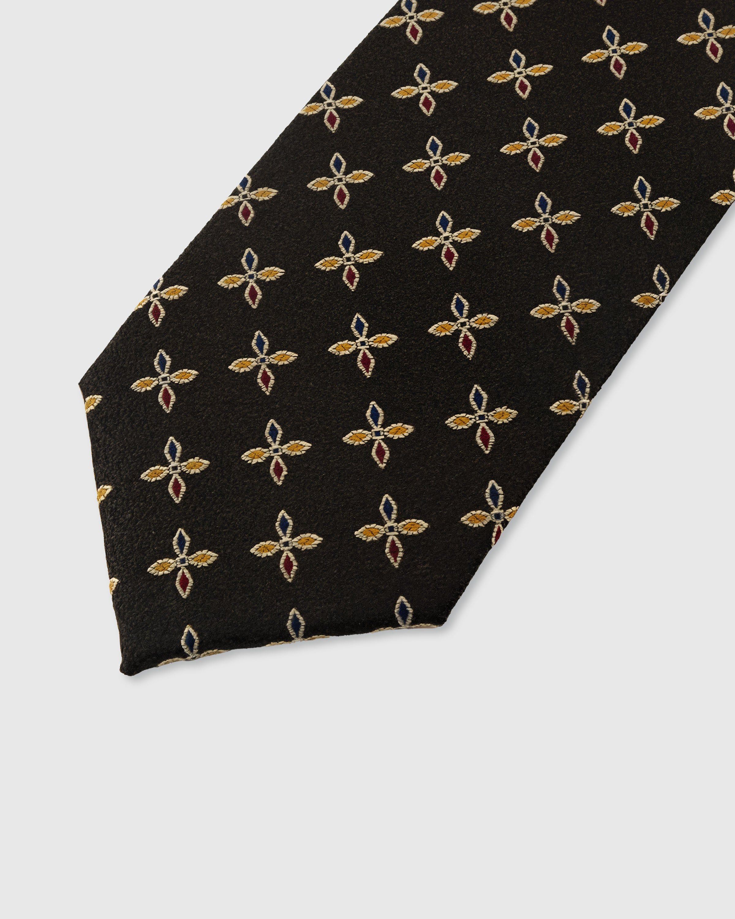 STICKYZOO ONYX PETAL TIE — hand-embroidered detail showing gold and russet four-petal leaf motifs, stitched not printed