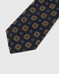 Gold quatrefoil medallion detail on navy mulberry silk tie showing hand-embroidered lobed frame by STICKYZOO