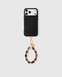 Full phone with amber stone strap attached on grey background