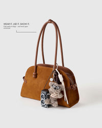 STICKYZOO POODLEGRAM plush poodle and working-camera charm clipped to a handbag handle