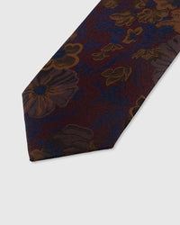 STICKYZOO BORDEAUX BLOSSOM TIE — hand-embroidered detail showing bronze and navy botanical blooms with blue fronds, stitched not printed