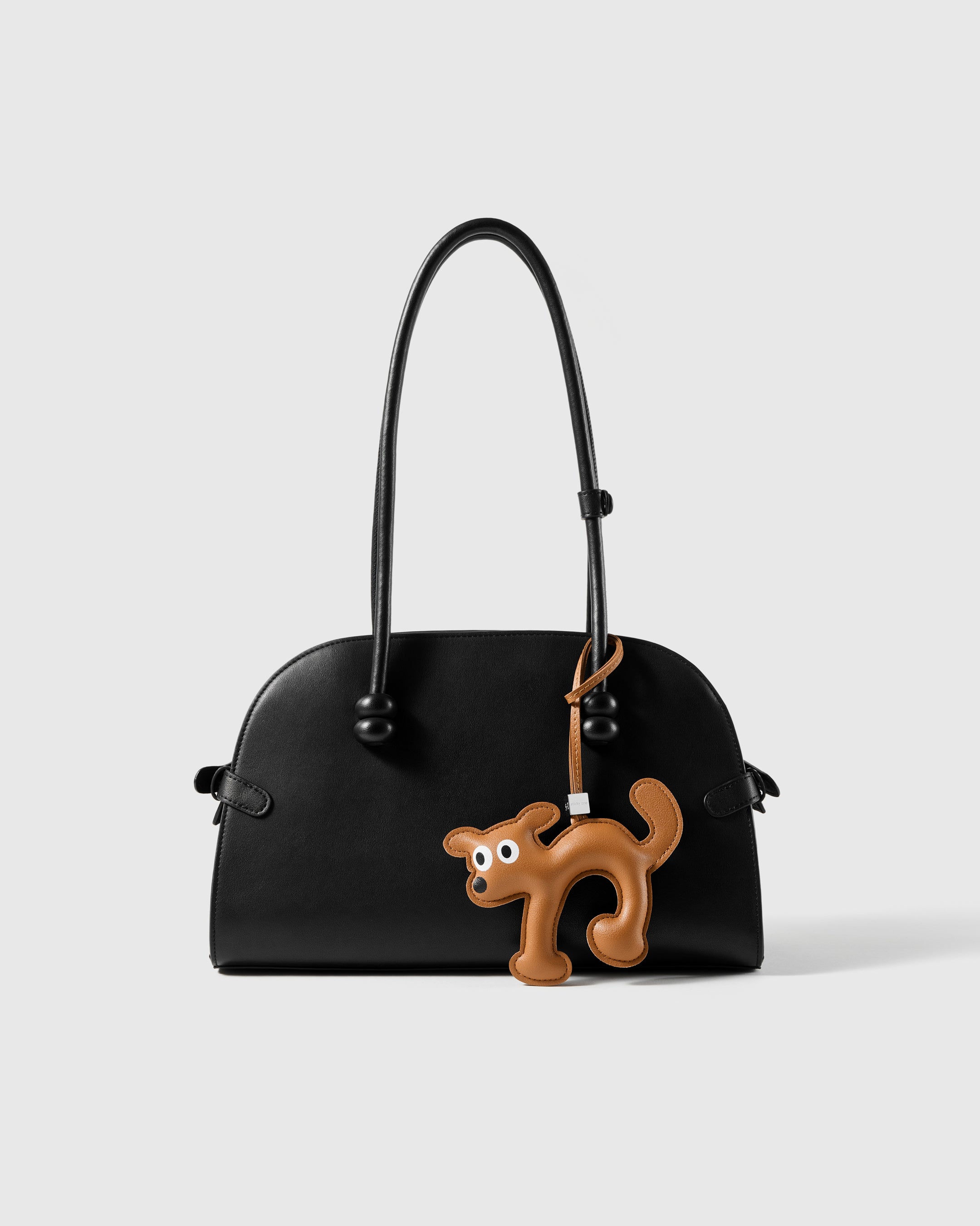 STICKYZOO leather running puppy charm styled on a handbag, a playful everyday detail