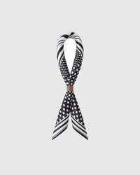 STICKYZOO monochrome dot grid silk scarf twisted through a leather ring showing how the print catches the light