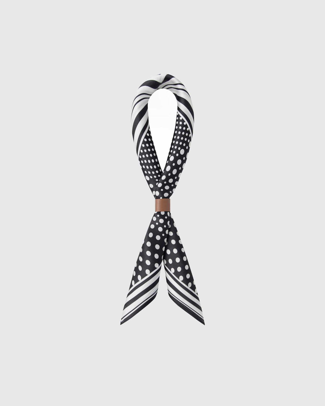 STICKYZOO monochrome dot grid silk scarf twisted through a leather ring showing how the print catches the light
