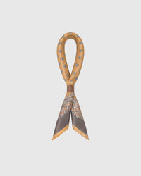 STICKYZOO amber foulard silk scarf looped through a leather ring showing how the printed silk falls
