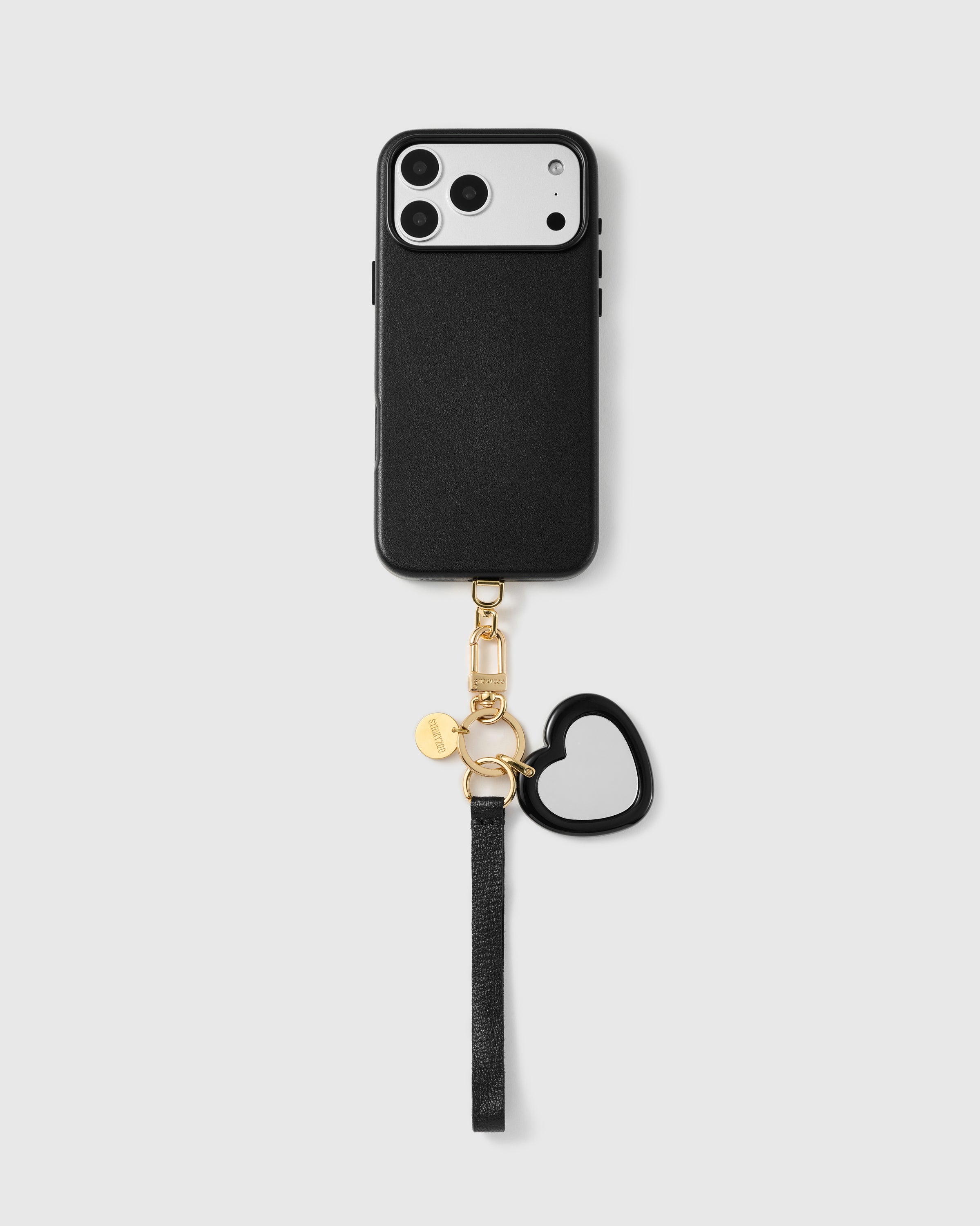 Close-up of pebbled French Alran leather phone strap showing hand-cut edge and engraved gold hardware