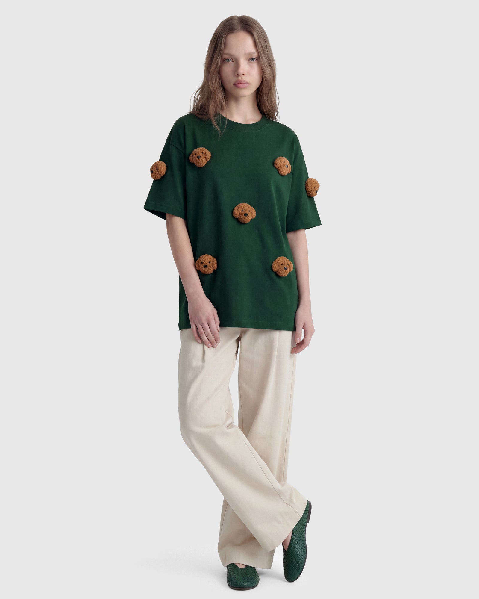 Model wearing STICKYZOO green Poodle Parade T-Shirt showing dropped shoulders and plush poodles