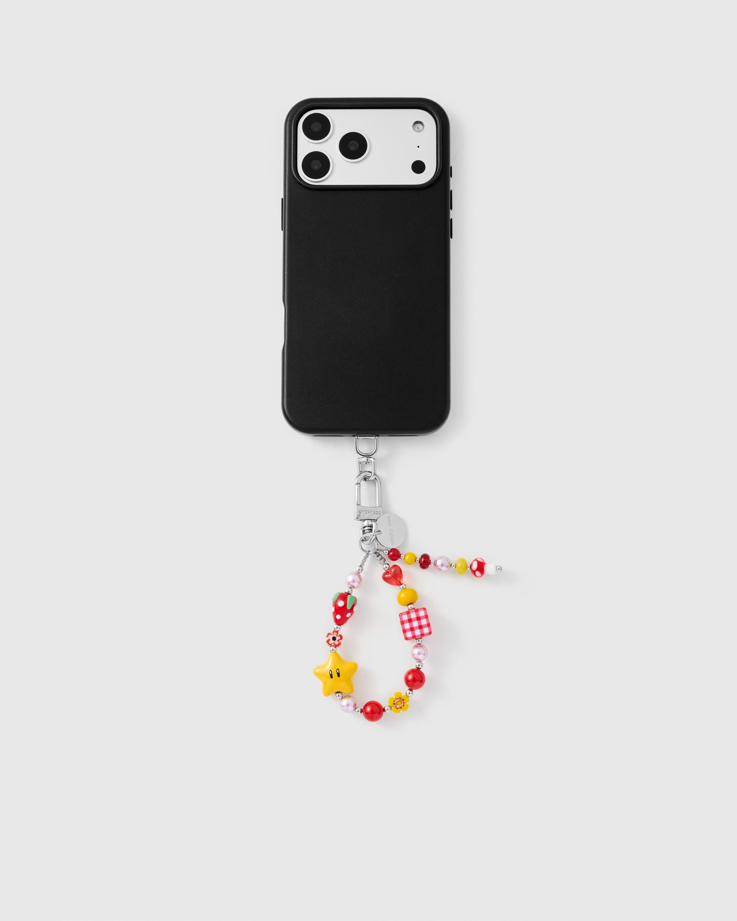 {{Works with any case}} Full phone with cherry star cluster strap attached on grey background