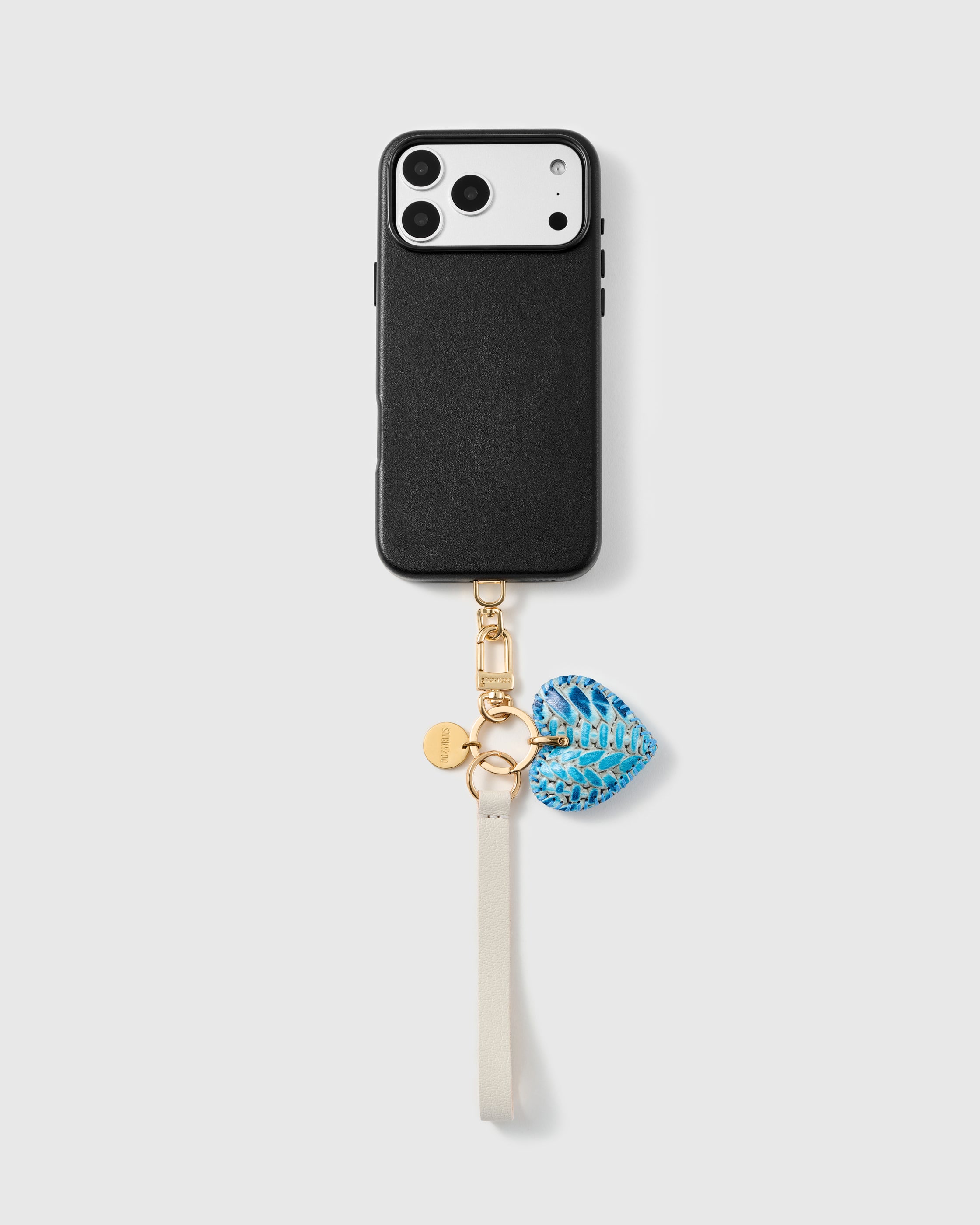 Azure python heart leather phone strap clipped to a black phone case, hands-free ivory wrist strap